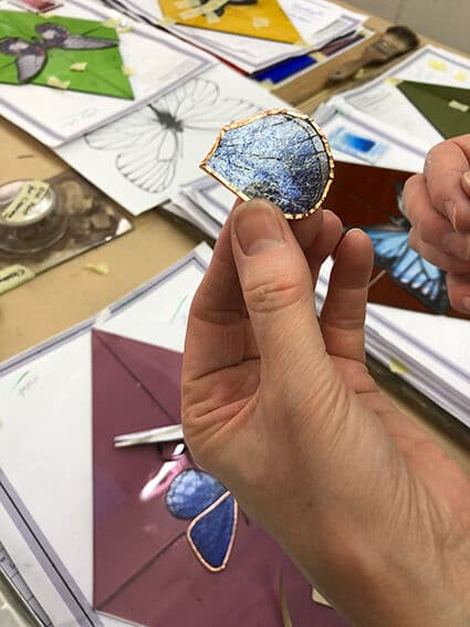 A small butterfly panel being wrapped in copper foil