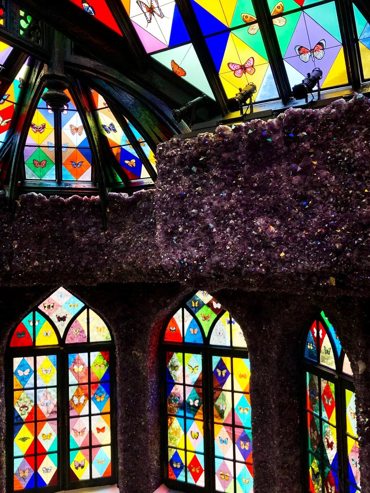 Wide interior view showing the stained-glass roof above the three doors