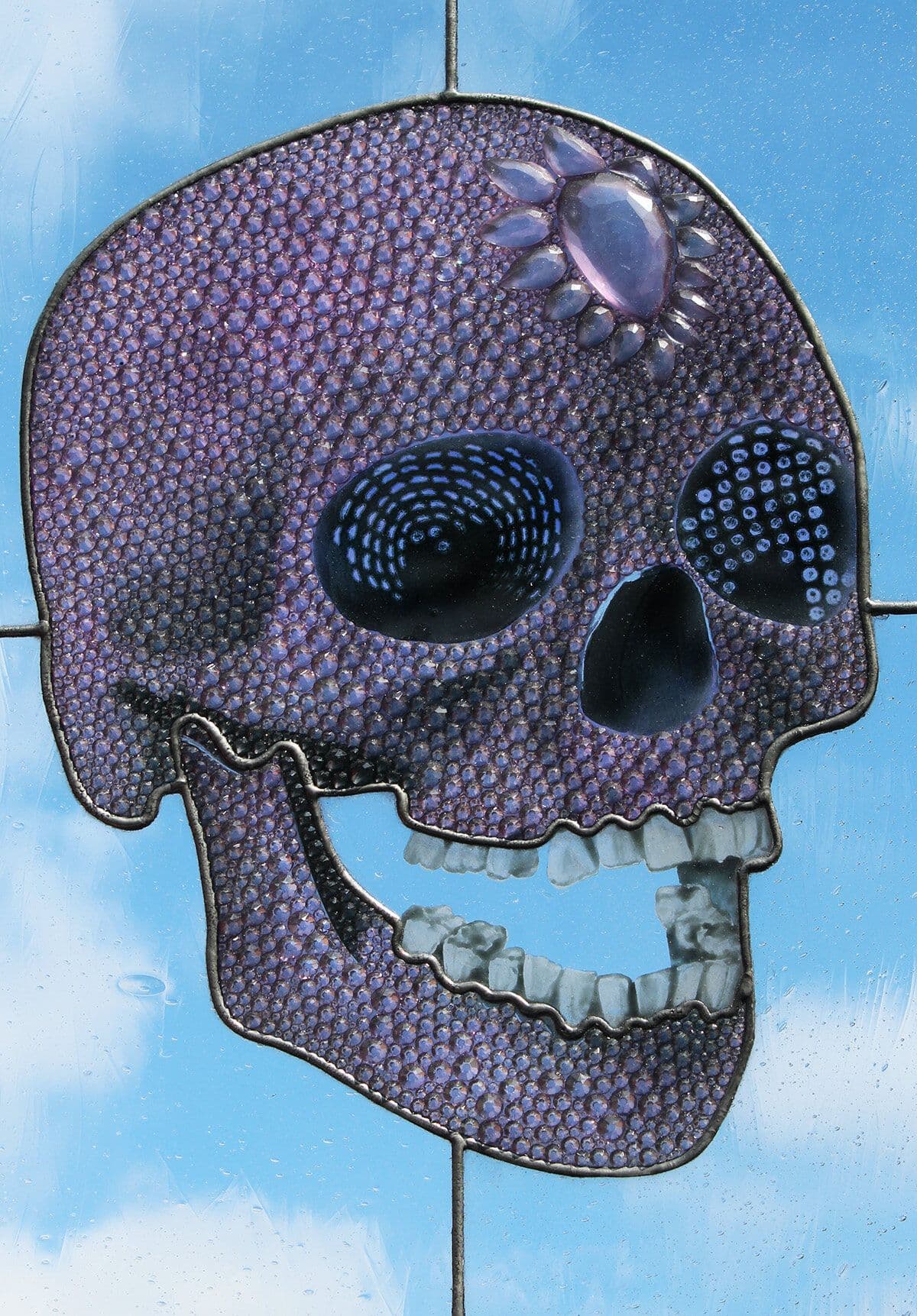 Completed purple skull window photographed against a blue background