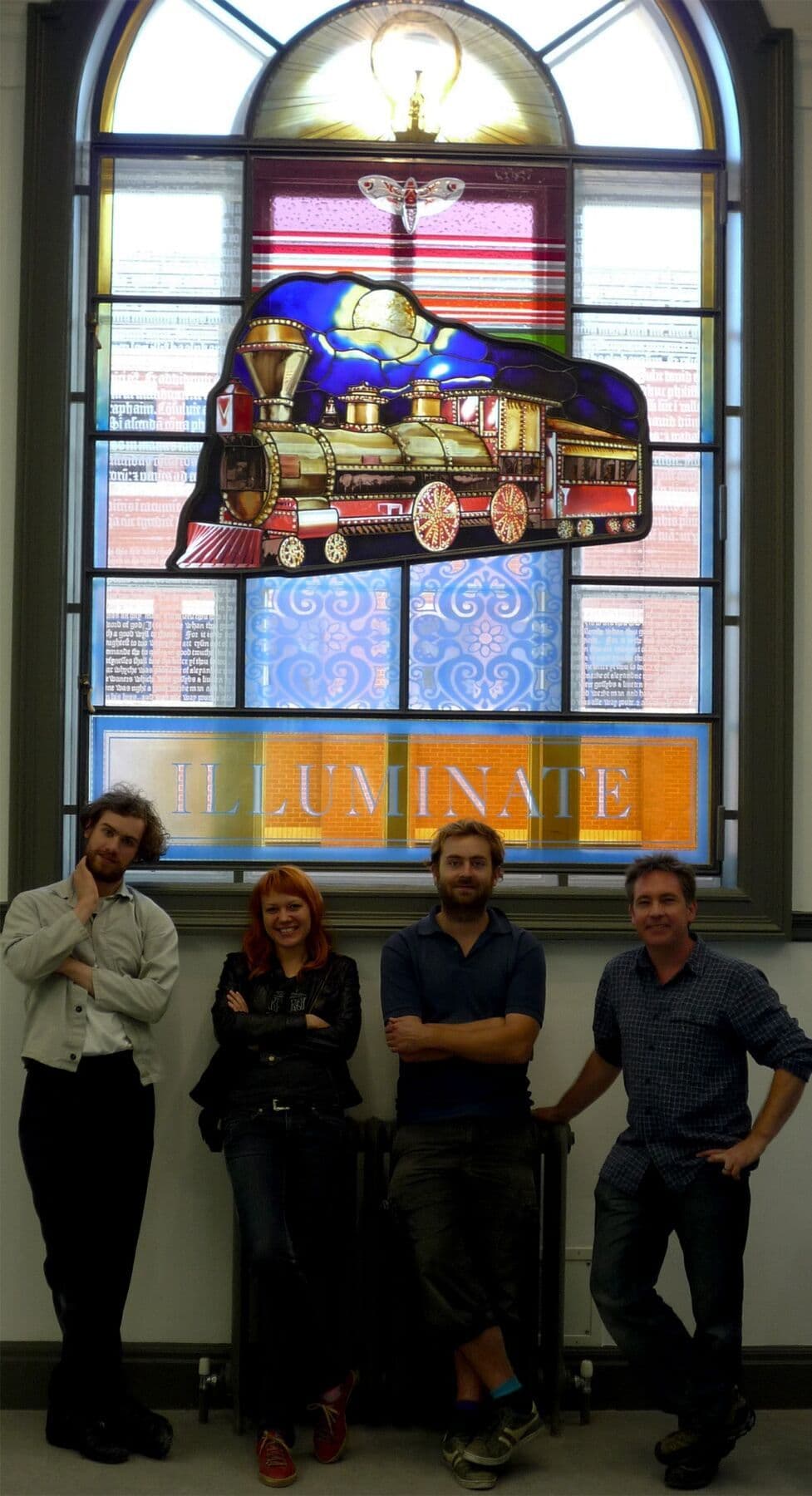 The Rainbow Glass Studios team standing with the installed train window
