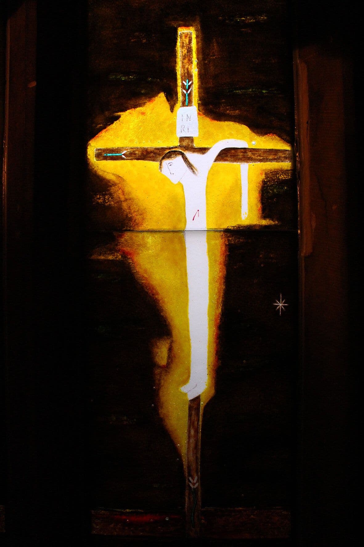 The completed crucifixion section glowing on a dark lightbox