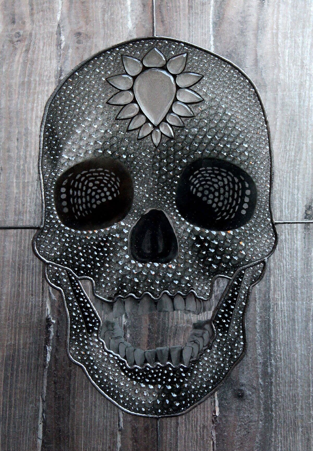 Completed crystal-covered skull window photographed against wood