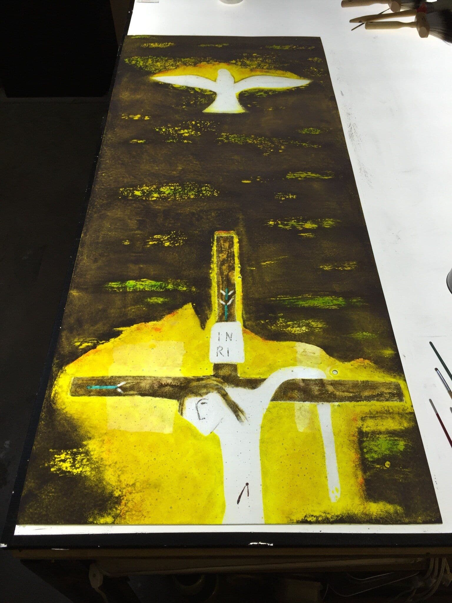 The complete window with crucifixion, lamb and dove illuminated on a lightbox